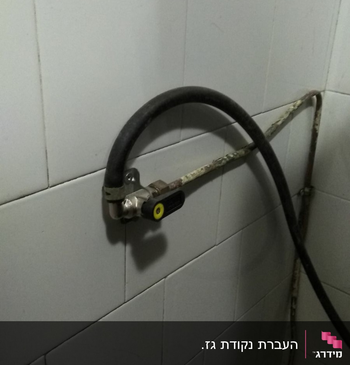צינור גז מחובר לשסתום על קיר אריחים
